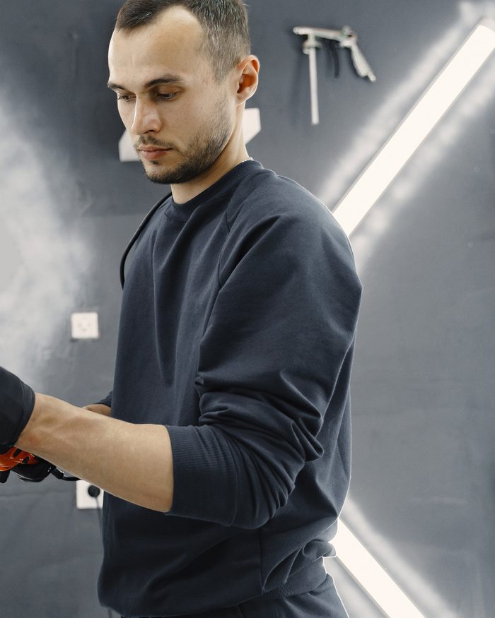 Technician machine-polishing car paint to a shine