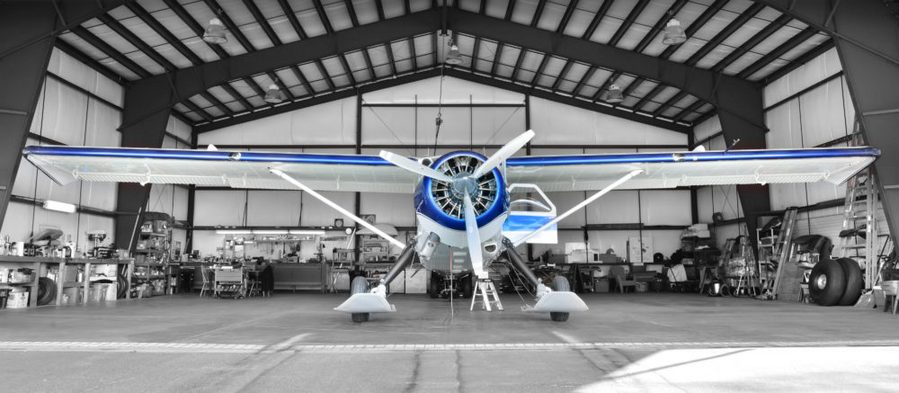 Small personal propeller plane parked inside a home hangar