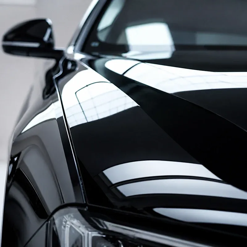 Glossy black car hood with a mirror shine after a full detail