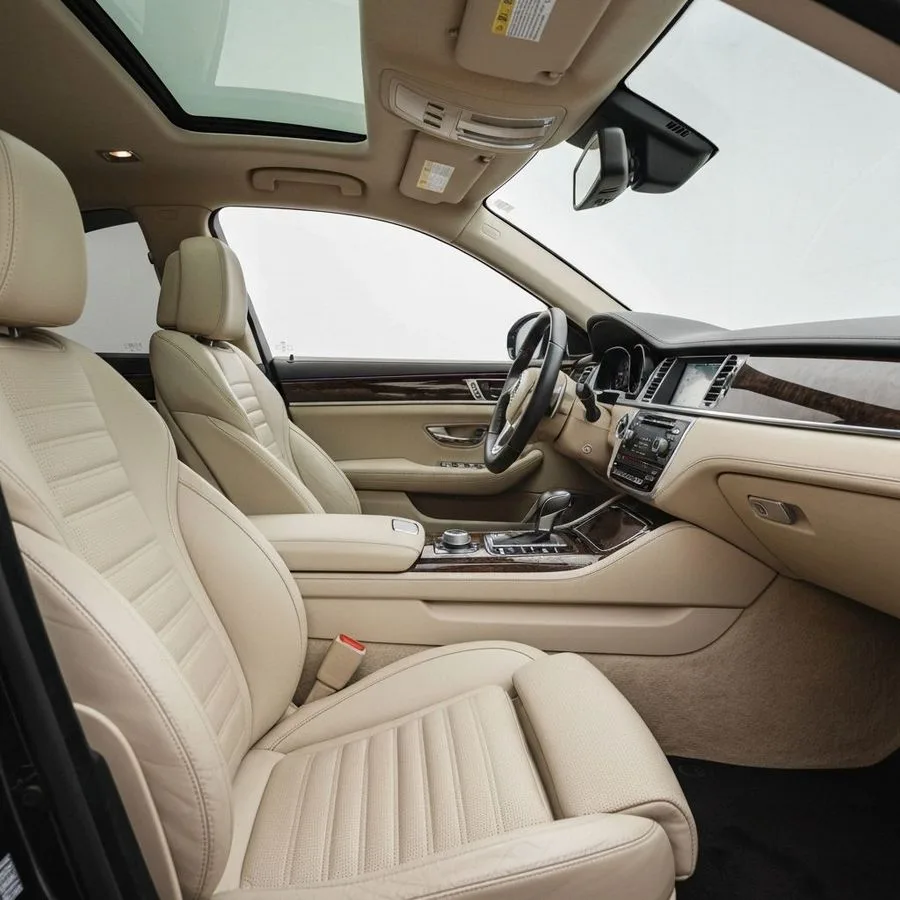 Interior impecable de auto de lujo con asientos de cuero crema después de un detallado