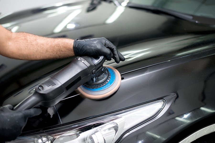 Machine polishing a glossy hood during a full detail in Indianapolis
