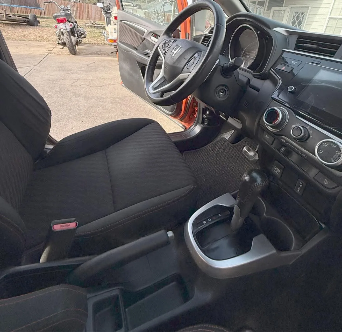 Foto real del tablero y el volante de un auto antes del detallado interior, con polvo y uso diario